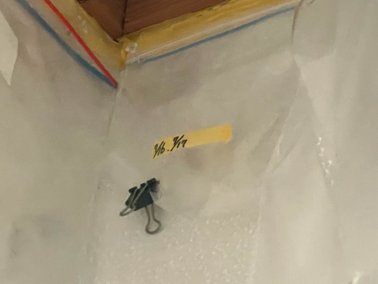 室内壁の雨漏り箇所をクリップと日付入りテープで確認している様子