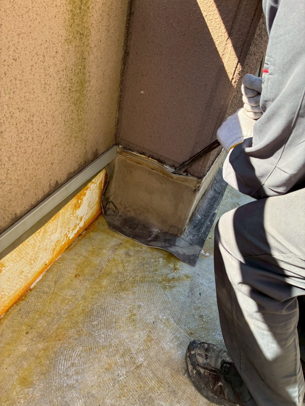 屋上の壁と床が接する立ち上がり部分へ防水材を施工している様子