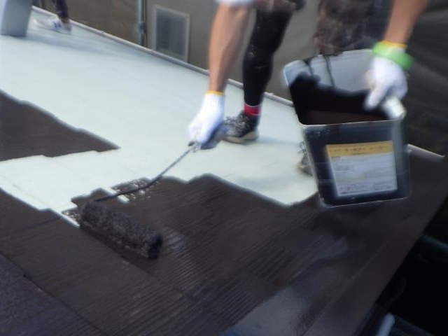 こげ茶系の塗料による屋根の1回目の上塗り