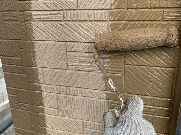 茶色系の塗料を塗る外壁の上塗り